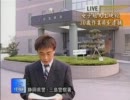 男性レポーターの背後から手が