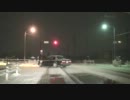 ノーマルタイヤの車、雪で滑りながら走る