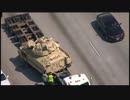 フリーウェイ上で、積荷の軍用車両がトレーラー荷台から落ちる(米 03/26)