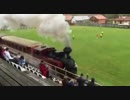 サッカーのグラウンドと観客席の間を走り抜ける蒸気機関車