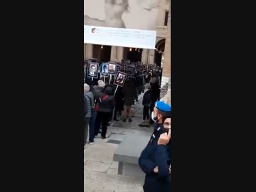 遺影を掲げて抗議デモ