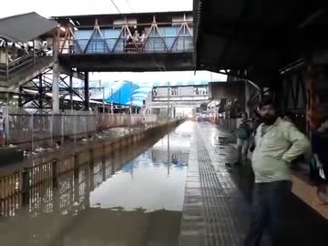 雨の後に駅を通過するインド鉄道