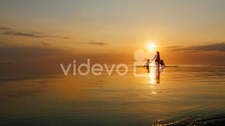 Mother With Two Children Laughing In The Sea At Sunset Out Of The Water　石川崇弘