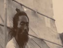 100年前の写真に残る韓国人　11　　先生と生徒？、釜山の海岸沿いの村、傘を持ってロバに乗る、荷物を背に負う、お腹に箱を乗せた 2 人の子供。背景には大きな帽子をかぶった白いスーツを着た男、