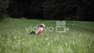 A young woman does yoga exercises in a field of grass