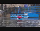 A kayaker paddles and gets carried away by the current of the river water around the embankment