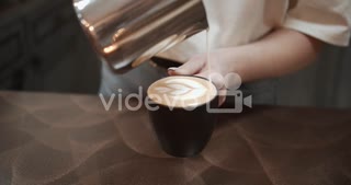 Bartender pouring hot milk into coffee in restaurant, real time close up