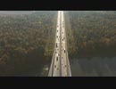 Cars driving on a straight road surrounded by nature