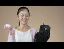 A woman lightly throwing a ball into a baseball mitt. 長尾信太郎