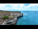 The drone is flying around cliffs above the ocean in Curacao Aerial Footage 4K