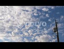 Fluffy clouds float by over the power lines - time lapse cloudscape