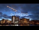 Illuminated crane and buildings at construction site on Malmo waterfront, drone