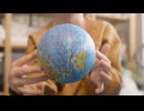 Close up view of unrecognizable kid playing with a globe in a craft workshop