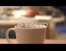 Close-up shot, pouring hot tea from a black teapot into a white cup