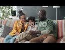 Cheerful African American Family Using Digital Tablet on Sofa at Home