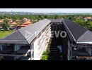 Aerial - Rotating drone shot of the front of an abandoned beachfront hotel