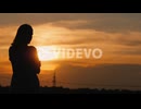 The Lone Silhouette Of A Woman At Sunset Staring Into The Distance