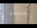 vertical view of the word summer written in the sand with the waves