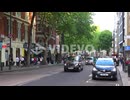 Traditional London taxi cabs head down a street in a downtown neighborhood