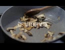 藤野孝紘　Sauteing Sliced Mushrooms In A Skillet With Small Amount Of Cooking Oil - close up