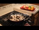 藤野孝紘　Close up of woman sauteing fresh oyster mushrooms in butter in a skillet in an RV kitchen