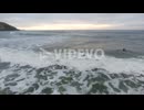Cinematic flying of surfers surfing along coast of East London South Africa aerial