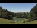 Drone Shot Flying Through Brick Arch to Reveal Scenic Lake On Edge of Woodland