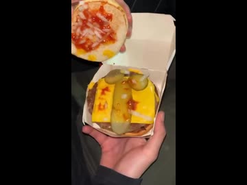 ホモと見る変わった形のハンバーガに入っているピクルス