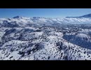 On a sunny day in snowy high mountains, an amazing sight unfolds. The white blanket of snow gleams u
