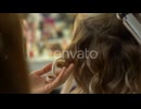 Closeup of Professional Female Hairdresser Making Hairstyle Using Curling Iron