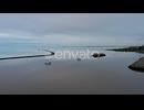Aerial view over tranquil water and peaceful seascape at sunset.