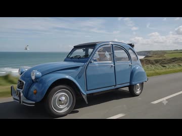シトロエン2CVがノルマンディーの海岸道路を走っている